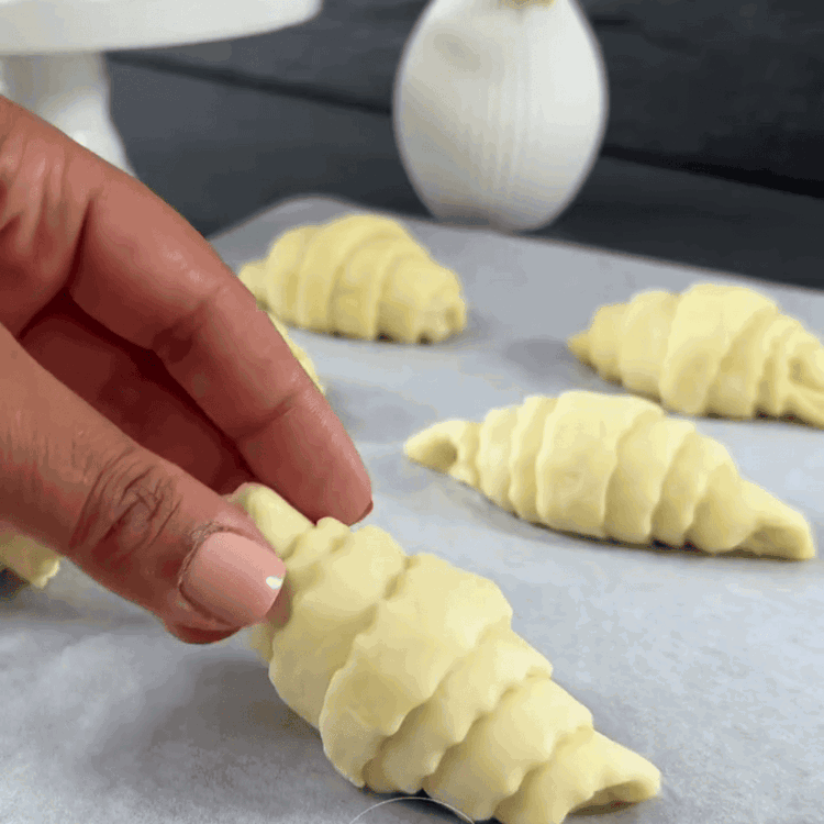 Image of Coloca las piezas de masa enrolladas en una bandeja para hornear forrada con papel pergamino.