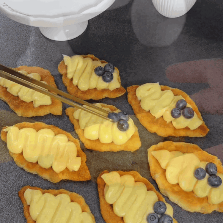 Image of Rellena los croissants planos con tiras de pudín. Decora con arándanos frescos.