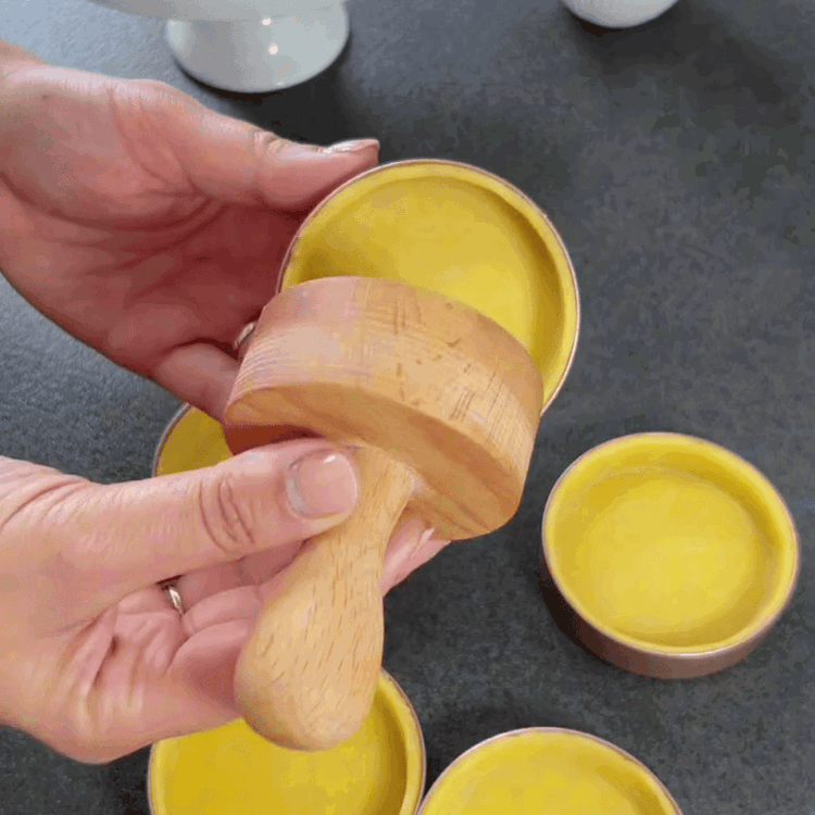 Image of Rollen Sie den gekühlten Teig auf einer leicht bemehlten Fläche aus. Stechen Sie Kreise aus, die etwas größer sind als die Tartelettformen. Legen Sie die Teigkreise in die gefetteten Tartelettformen und drücken Sie sie sanft an. Stechen Sie die Teigböden...