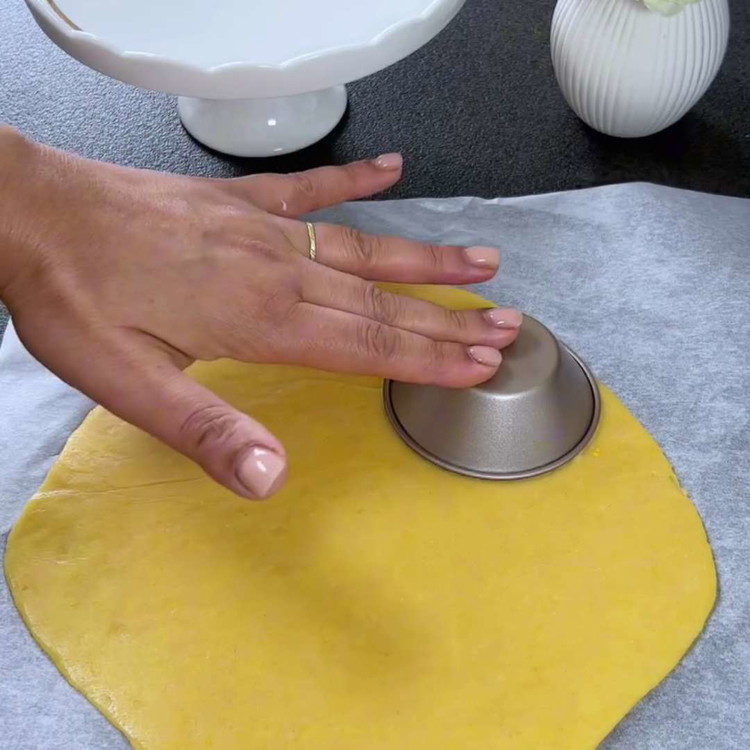 Image of Hamuru açın ve tartlet kalıplarını kaplayın, hamuru kenarlarına doğru bastırın.