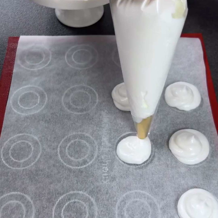 Image of Dressez le mélange de meringue en 12 petites mounds rondes sur la plaque préparée, en lissant légèrement 6 d'entre elles.