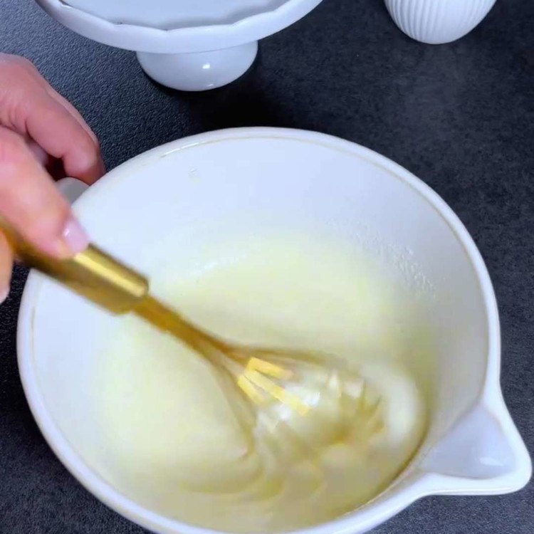 Image of Sbatti le uova in una ciotola, aggiungi lo zucchero e mescola bene fino a ottenere un composto cremoso.