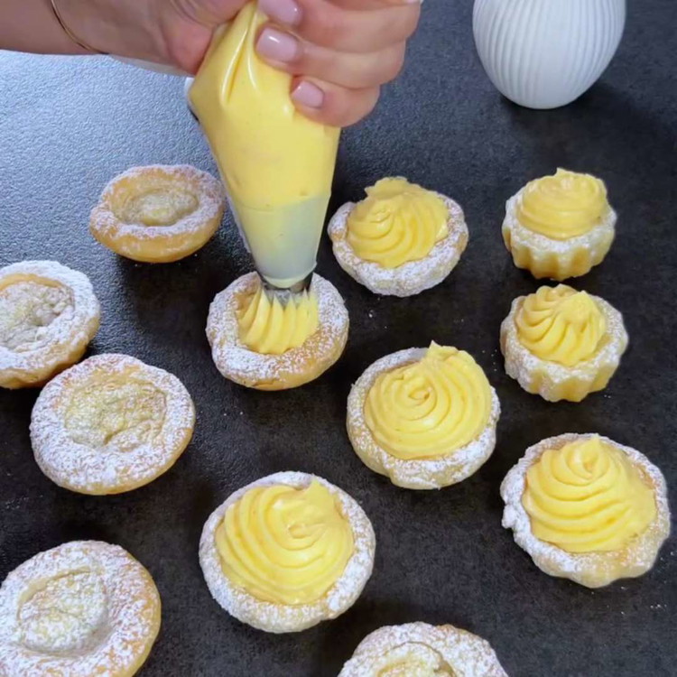 Image of Die abgekühlten Blätterteigteilchen mit der Vanillecreme mithilfe eines Spritzbeutels füllen.