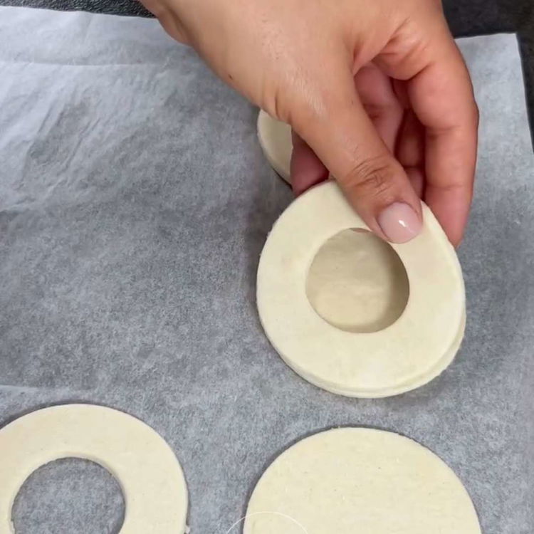 Image of Aseta renkaat leivinpaperilla vuoratulle pellille. Voitele renkaat kananmunan keltuais-maitoseoksella ja...