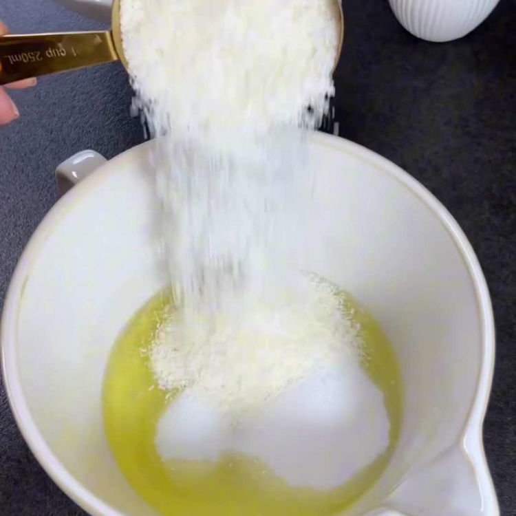 Image of Bir tencerede düşük ateşte şekeri, rendelenmiş hindistan cevizini, yumurta aklarını...