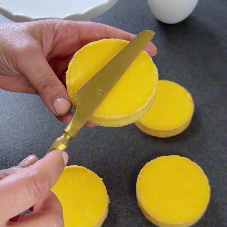 Image of Pudra şekeri ve limon suyunu pürüzsüz olana kadar karıştırın. Tartelettlerin üzerine dökün ve desenler oluşturun.