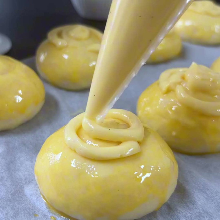 Image of Placez des bandes de crème pâtissière sur les boules de pâte.