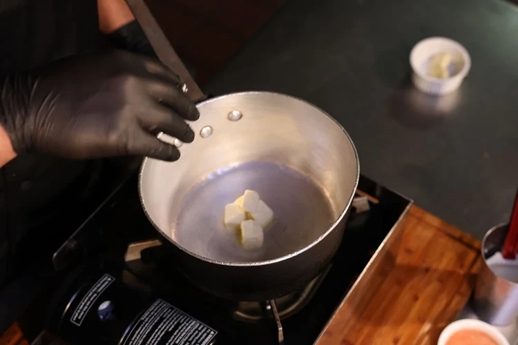 Image of In a saucepan, melt butter over low heat.