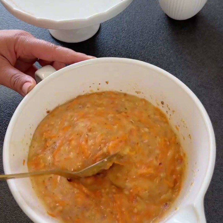 Image of Add the grated carrots and chopped walnuts to the wet mixture and mix well