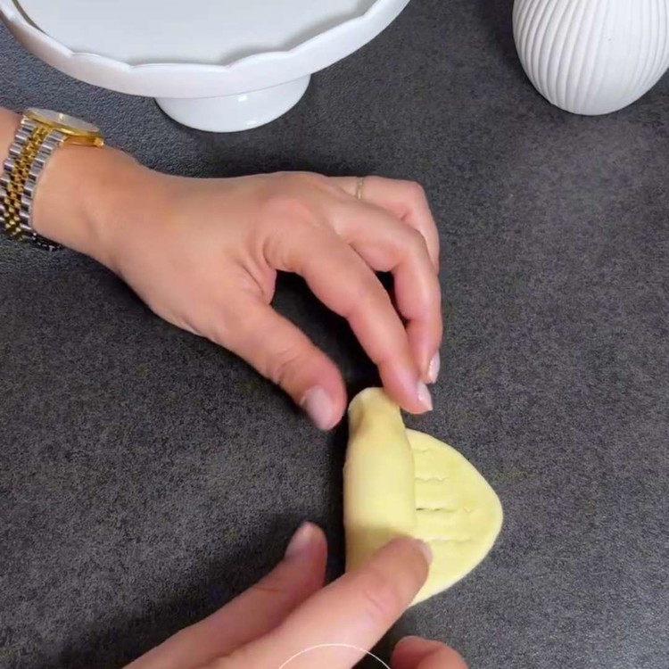 Image of Jeweils 1 Teelöffel Marmelade am Anfang jedes Ovals platzieren, falten und verschließen. In der Mitte Einschnitte machen, nicht ganz durchschneiden, und zu Crescents rollen.