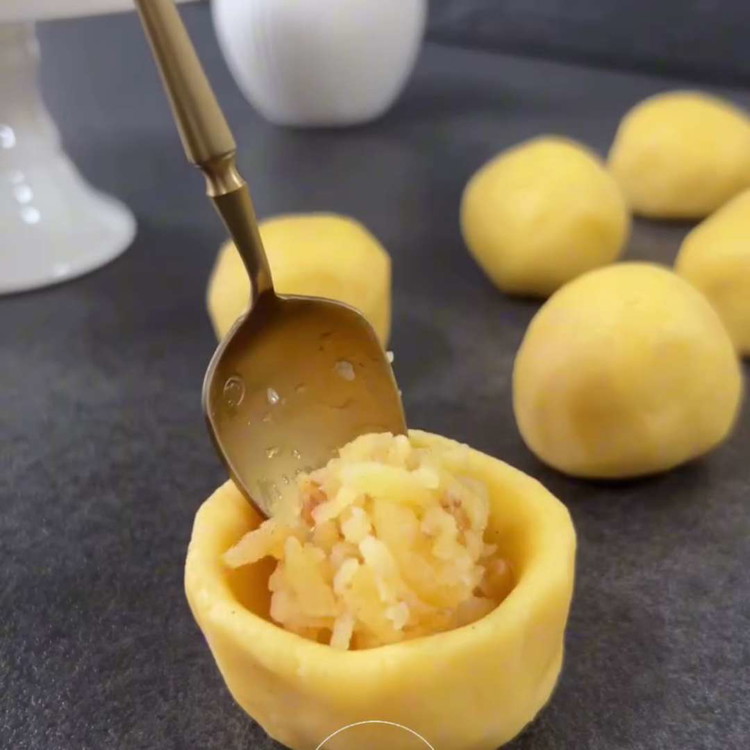 Image of Mélyedj el minden golyóban, töltsd meg egy teáskanál előkészített birsalma töltelékkel, és óvatosan zárd le a széleit.