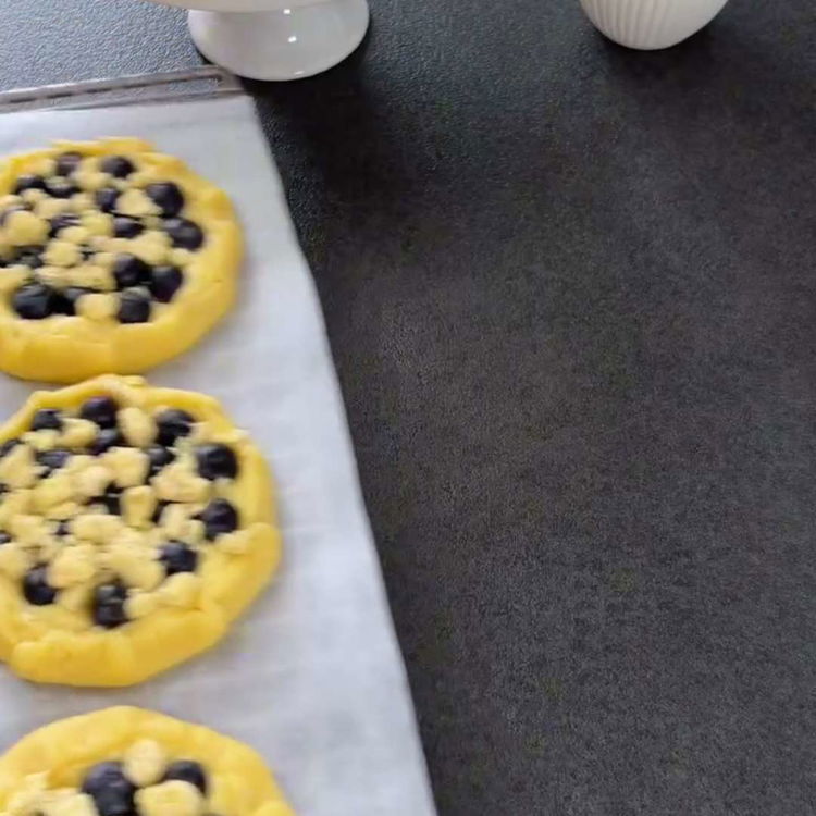 Image of Presărați topping-ul crumble uniform peste umplutura de afine.