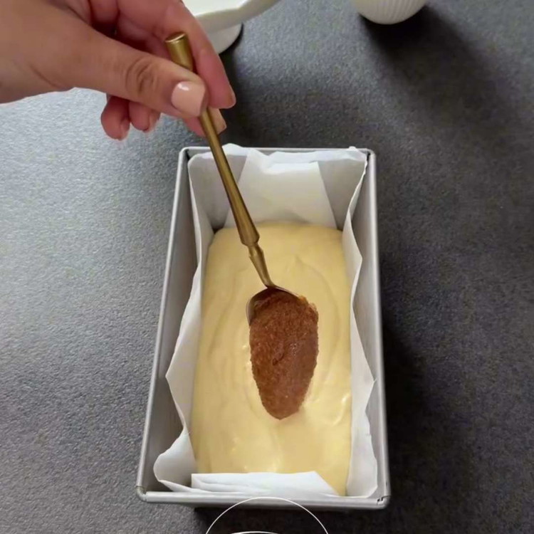 Image of Despeje um terço da massa na forma de pão e alise. Espalhe metade do recheio de canela no centro por cima. Adicione a segunda camada de massa, seguida pela metade restante do recheio de canela. Por fim, adicione a última...