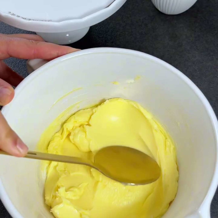 Image of In einer Schüssel die weiche Butter und den Puderzucker cremig rühren, bis eine glatte Mischung entsteht.