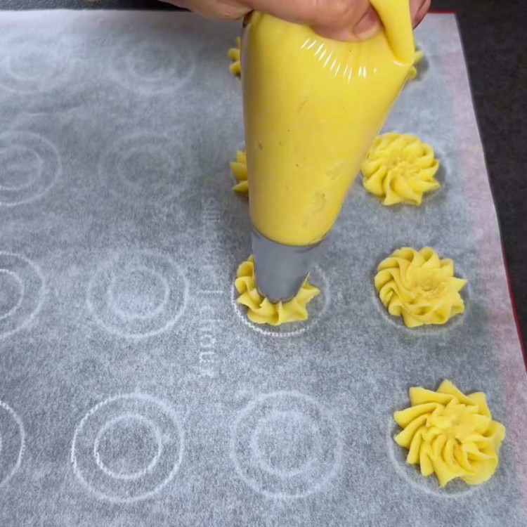 Image of Spritz den Teig auf ein mit Backpapier ausgelegtes Blech, um die gewünschten Formen zu kreieren. Lassen Sie Ihrer Kreativität freien Lauf!