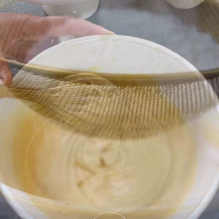 Image of Setaccia la farina, il lievito e il sale sul composto e piega delicatamente fino a quando non è appena combinato. Fai attenzione a non mescolare eccessivamente l'impasto.