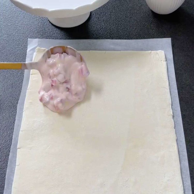Image of Verteilen Sie die vorbereitete Erdbeer-Quark-Mischung auf einer Seite des Blätterteigs und lassen Sie an den Rändern etwas Platz.