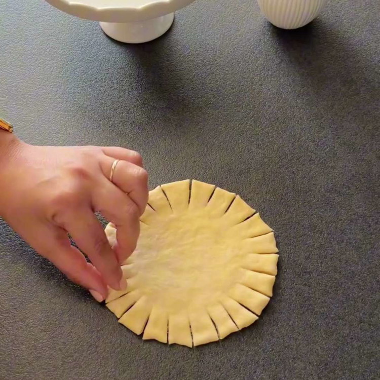 Image of Mehrere kleine Schnitte um die Markierung herum machen. Jedes geschnittene Stück überkreuzt (abwechselnd links und rechts) falten, um einen geflochtenen Look zu erzeugen.