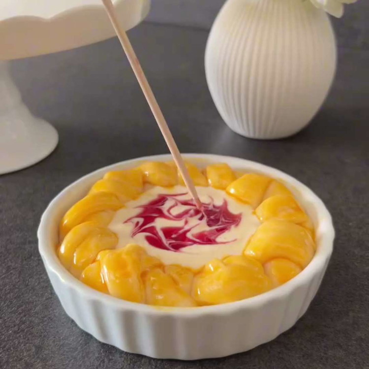 Image of Drei kleine Punkte Marmelade auf die Quarkfüllung geben und vorsichtig mit einem Zahnstocher verwirbeln, um einen marmorierten Effekt zu erzeugen.