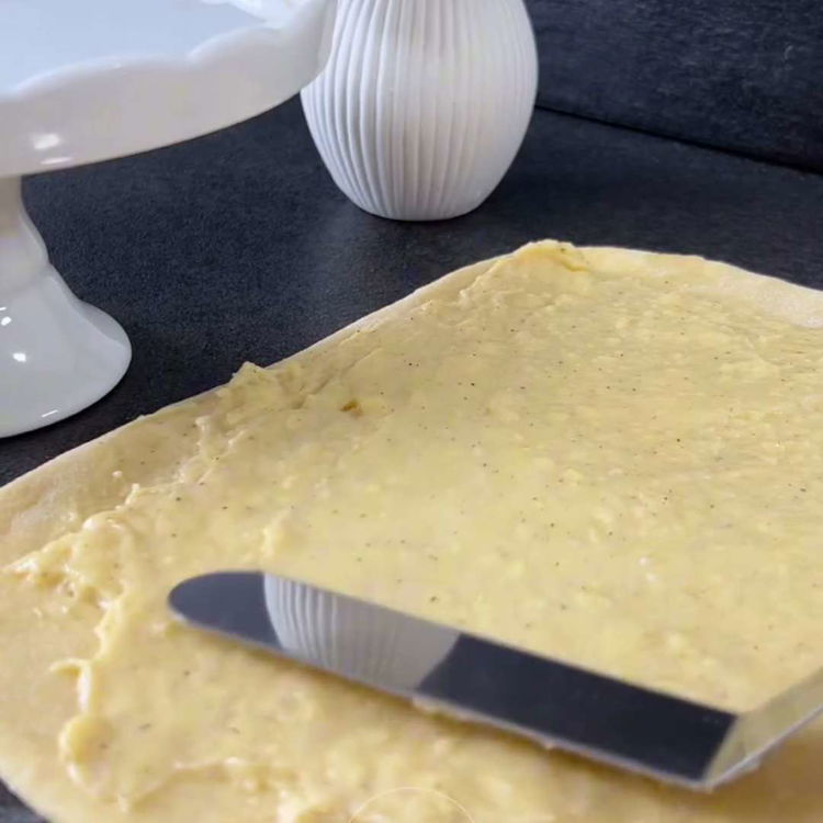 Image of Întindeți crema de vanilie răcită uniform peste aluat. Rulați aluatul...