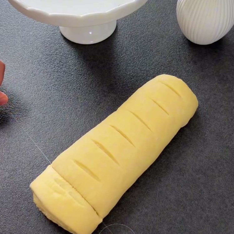 Image of Cortar el rollo en rebanadas de aproximadamente 2 cm de grosor, aplanarlas ligeramente y colocar las rebanadas en una bandeja para hornear forrada con papel pergamino. Dejar que los remolinos leven nuevamente durante otros 15-20 minutos.