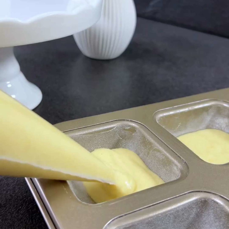 Image of Evenly distribute the batter into the prepared twelve molds.