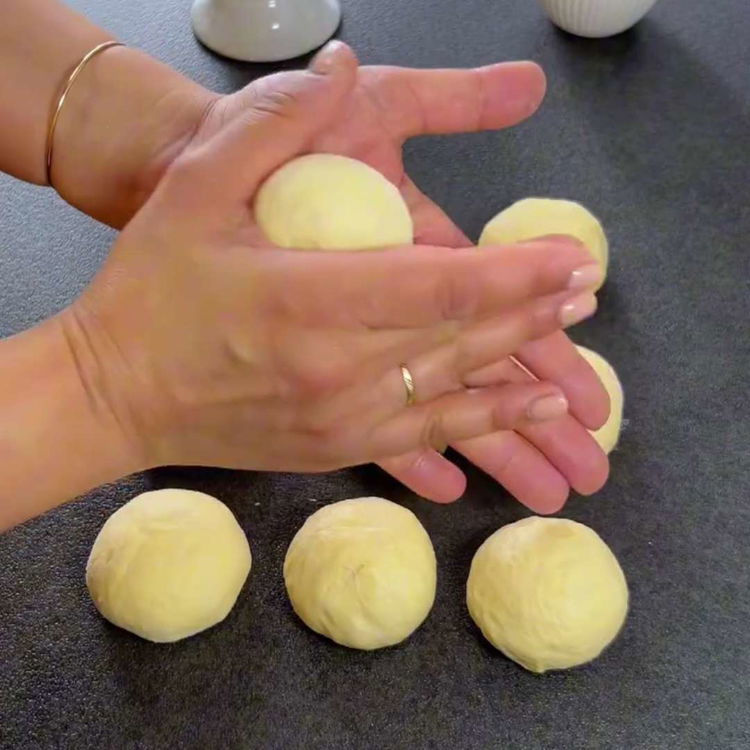 Image of شكل العجينة المختمرة إلى رول على سطح مرشوش بالدقيق. قطع...