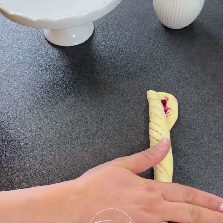 Image of Leikkaa viiltoja jokaisen taikinapinnan keskelle (ei läpi asti) ja rullaa se yhdeltä puolelta spiraaliksi. Varmista, että mustikkahillo on tasaisesti jakautunut ja näkyvissä ulkopuolelta.