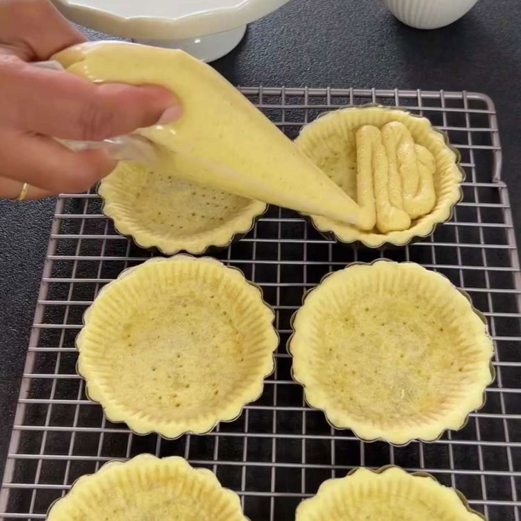 Image of Soğuyan tartlet kabuklarını badem kreması ile doldurun ve üstlerini düzeltin....