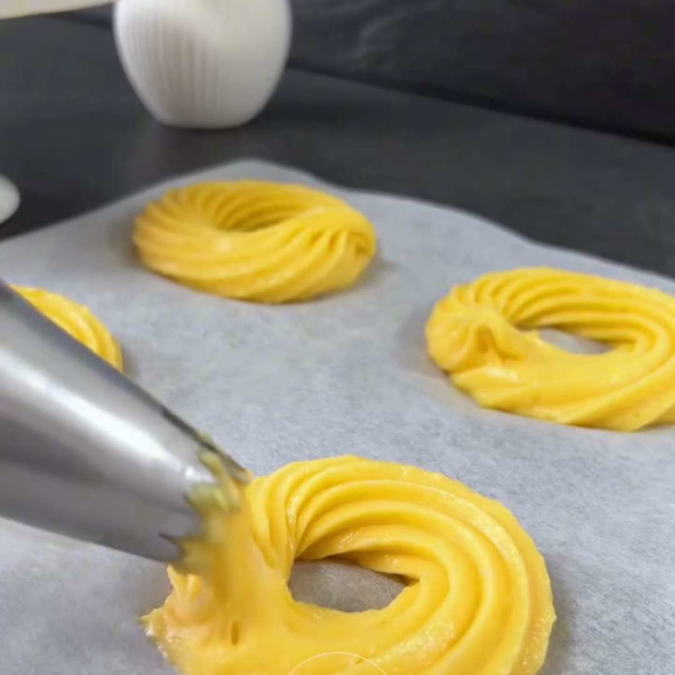 Image of Forma dei cerchi di impasto su una teglia rivestita di carta da forno. Cuoci le zeppole nel forno preriscaldato per circa 35 minuti, fino a doratura. Evita di aprire la porta del forno durante la cottura per non far collassare...