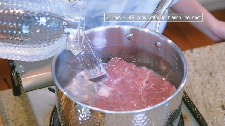 Image of Add the beef to a big pot and fill it with 2 liters or enough water to immerse the meat. Partially put on the lid and bring it to a boil over high heat.