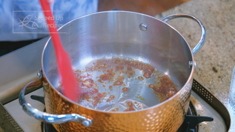 Image of Add the oil and sugar to a separate pot and stir the sugar over low heat until caramelized; this will take about 3 minutes.