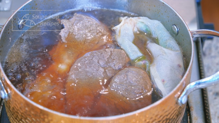 Image of Add the spice bag into the stockpot and switch the heat to low. Simmer the beef for 2 hours or until tender.