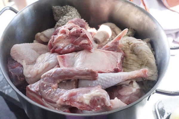 Image of Season the beef, goat meat, and stockfish with onions, seasoning cubes, and salt. Add water and cook until soft, then add smoked prawns or dried fish and simmer for 5 minutes.