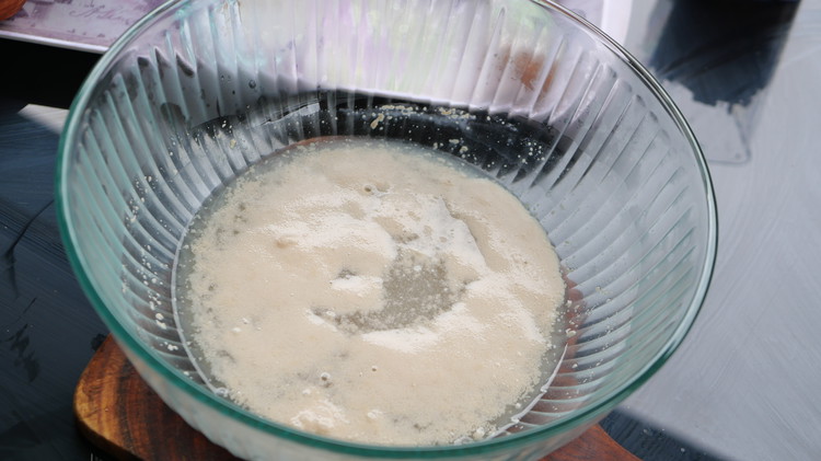 Image of In a large bowl, mix warm water, part of the sugar and yeast and set aside to activate 