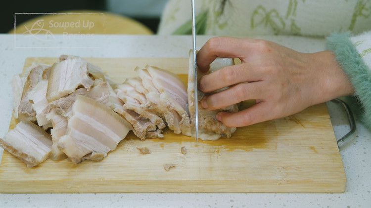 Image of Remove the pork belly from the pot, rinse it under running water, and wipe off the moisture with paper towels. Cut the pork belly into ⅛-inch thick slices.