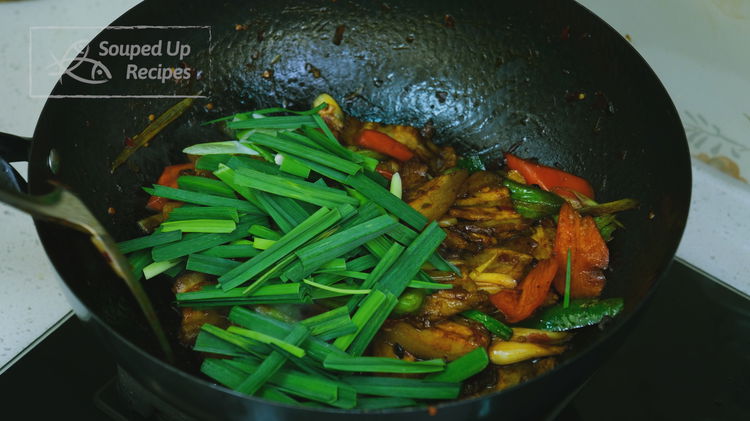 Image of Add the green part of the garlic sprouts and toss...