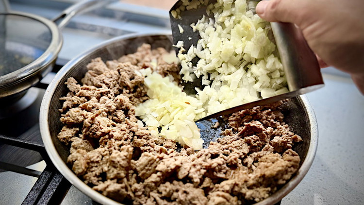 Image of clear a spot in the middle and cook onion and garlic until they start to darken slightly.