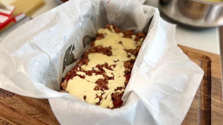 Image of in a bread tin or baking tray (lined with greaseproof paper and a hit of spray oil) line the base with lasagne sheets, then add your pasta sauce in an even layer and same, same with the béchamel sauce. Repeat...