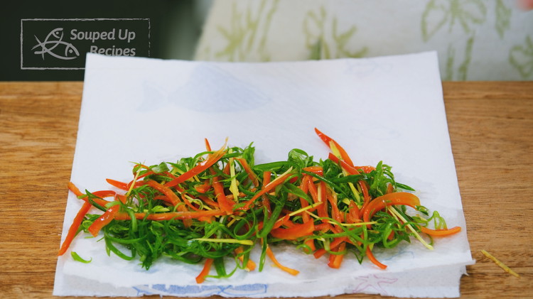 Image of Stack the green part of the scallion, ginger slices, and red chili pepper together and then thinly julienne them. Soak them in clean water for 10 minutes so they will curve naturally and make a better presentation. Remove them from...