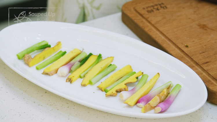 Image of Place the ginger strips and white parts of the scallion stalks on an oblong plate.