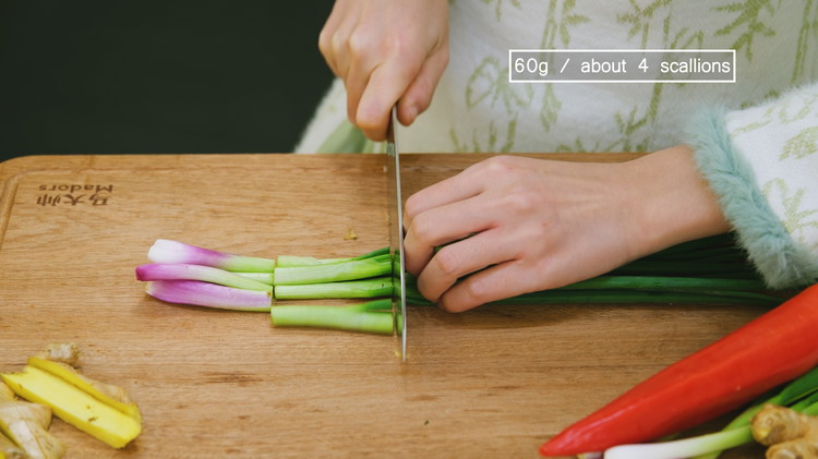 Image of Cut 3 inches of ginger into thick strips. Cut 4 scallions into 3-inch-long stalks. Separate the green and white parts. Cut the red chili pepper open and remove the seeds.