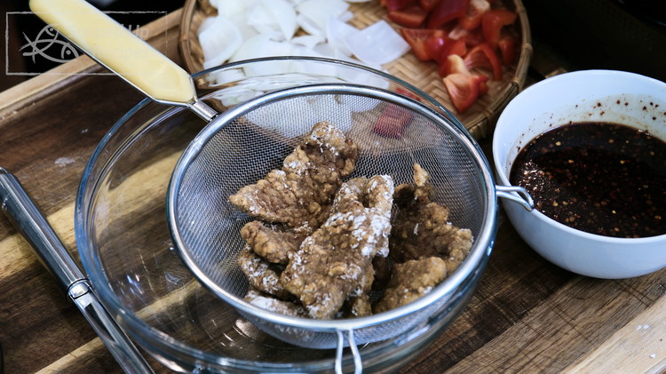 Image of Remove the beef to the side, use a sieve to skim all the cornstarch lumps, and continue to fry the next batch. You may need to fry all the meat in 2-3 batches, depending on the size of your cookware.