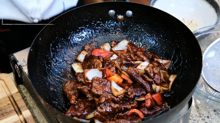 Image of Introduce the beef, bell pepper, and onion back to the wok. Toss thoroughly. Make sure every piece of the beef is coated with the sauce. Serve with white rice.
