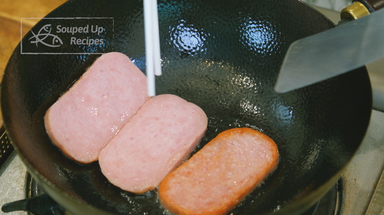 Image of Add 3 slices of spam, about 1/4 of an inch thick, to the wok and sear for 1-2 minutes per side or until both sides are slightly charred. Place the spam onto the rice. If you don'tdon't have spam, you...