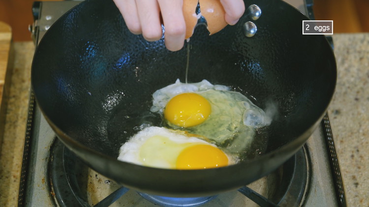 Image of To the same wok, crack in 2 eggs and pan fry to your desired doneness.