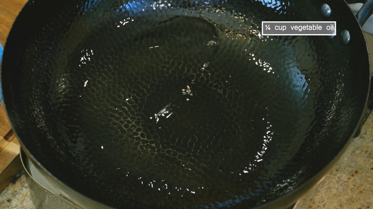 Image of Turn the heat to high and heat a wok until smoking hot. Add 1/4 cup of cooking oil and swirl it around so the oil creates a nonstick coating.