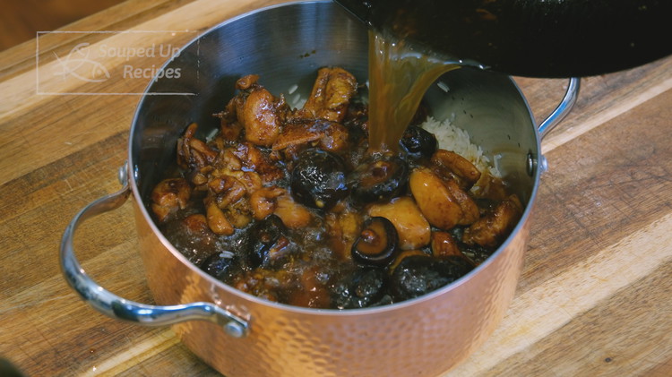 Image of Transfer all the ingredients from the wok into the pot where you have the rice. Use the mushroom-soaking water to rinse the wok and pour it into the rice.