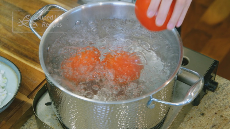 Image of Bring a big pot of water to a boil. Cut a cross on each tomato and add to the boiling water. Blanch for 30 seconds and remove from the water.