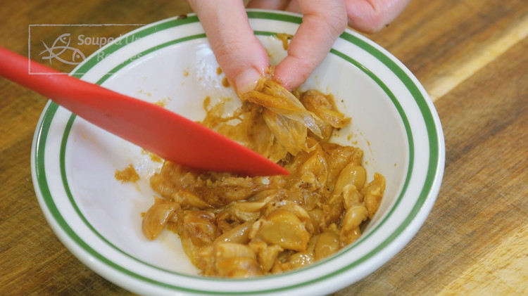 Image of While waiting, smash the soft garlic into a paste then pick out the peels.